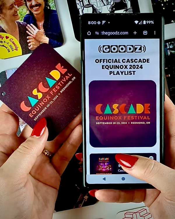 A Cascade Equinox Festival Custom Goodz card alongside a phone showing the official 2024 festival playlist.